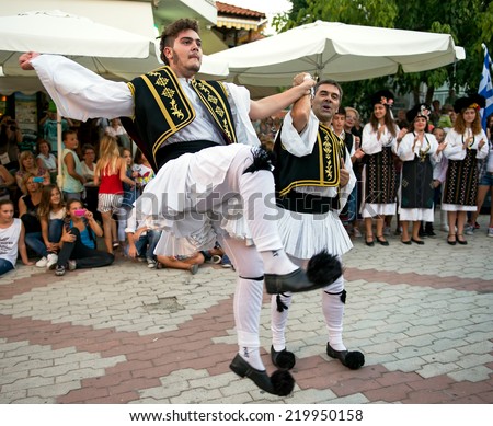 PEFKOHORI , GREECE - SEPTEMBER 19 2014 : Folk Dancers from several countries   dance in the Annual Folk Dance festival in the village square of Pefkohori ,Greece.The Greek dancers perform their dance.