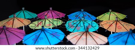 Vivid cocktail umbrellas\
High contrast of vivid colours against black background