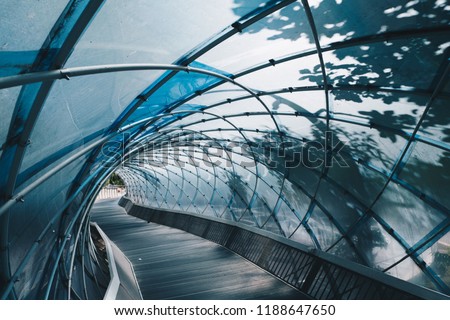 Structural glass facade curving roof and the wooden pathway inside. Modern and Contemporary architectural fiction with glass steel column.Abstract architecture fragment.  Anyang art park in korea