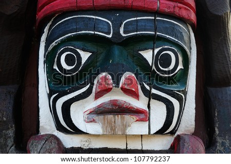 Lively carving faces on a totem pole by ancient native indian american, Victoria, British Columbia, Canada