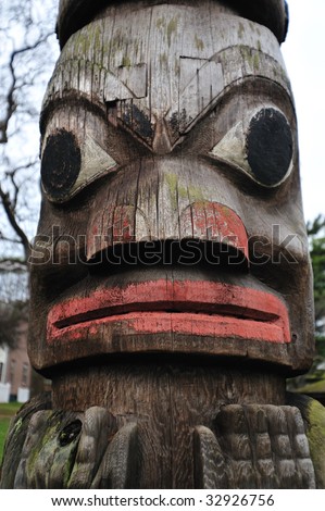 Lively carving face on a totem pole by ancient native indian american, Victoria, British Columbia, Canada
