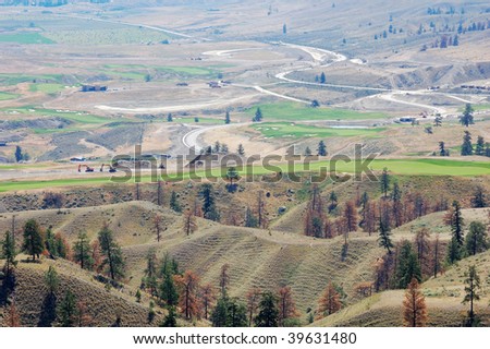 Roadside view of a rare green golf court and the surrounding desert-like barren landscape along the highway 1, kamloops, british columbia, canada