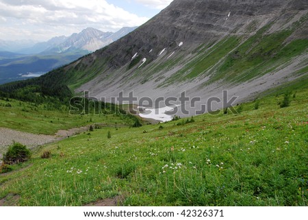 Summit view of mountain slopes, lake and meadows on the top of mountain indefatigable, kananaskis country, alberta, canada