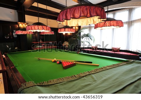 Billiards or pool balls on a green flet table with sticks