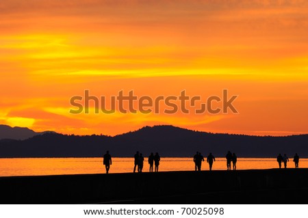 people walking on Ogden point breakwater in twilight, victoria, british columbia, canada