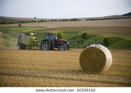 Agriculture landscape with straw bale and a tractor