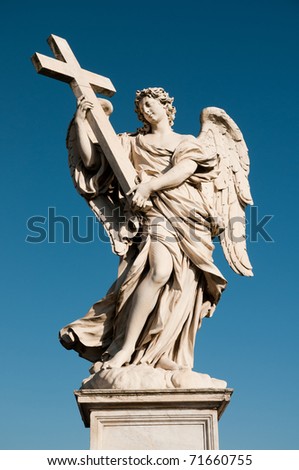 Holy statue of carved winged angel with cross in blue sky