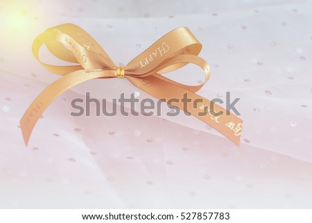 Golden ribbon bow tie on white dot fabric,Gold ribbon close up shot.