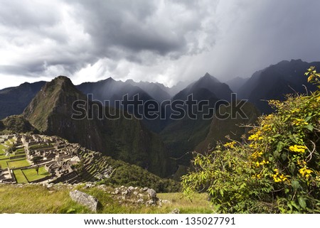 Black rain clouds gather above the ancient lost Inca city Machu Picchu in the Andes mountains in Peru, South America