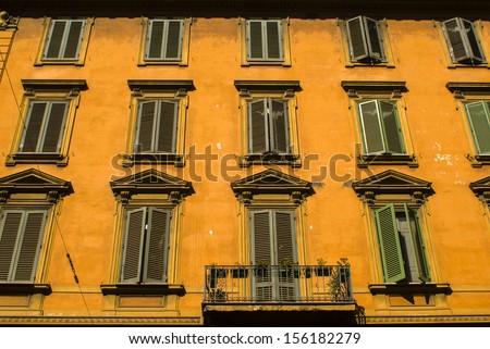 Yellow building with windows and balcony in the center of Rome, Italy