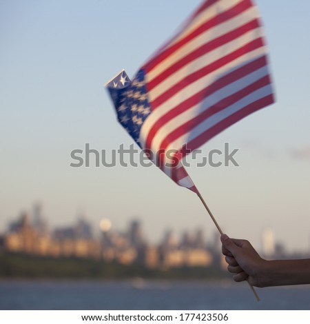 A child holds an American flag on a boat on the Hudson river in New York on the 4th of July. - New York City, United States of America