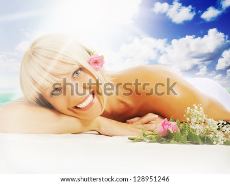 Young beautiful woman in a spa salon massage procedure on sunny tropical beach on the island paradise in the middle of the sea