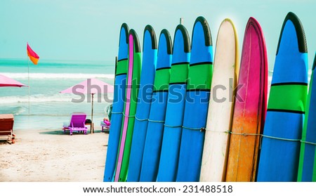 Set of color surf boards in a stack by ocean