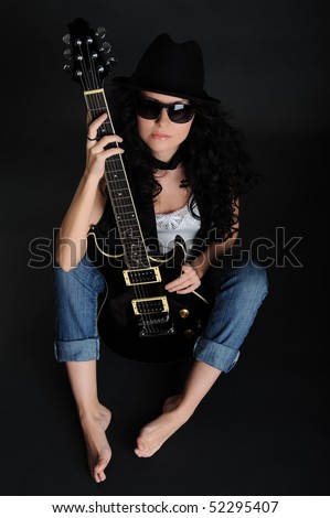 girl in a hat sitting on the floor with a guitar in his hands