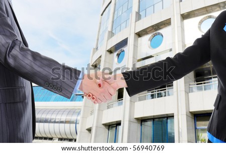 Handshake men and women against the background of the business center.