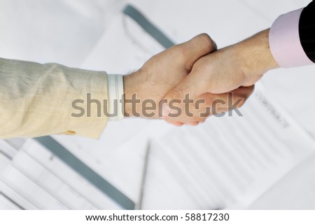 Handshake of two business partners in black and white suits