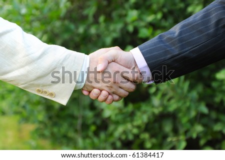 Handshake of men in black and white suits