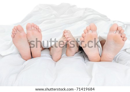 Close-up of the feet of a family on the bed. Isolated on white background
