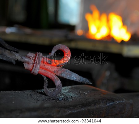 Blacksmith forges a red-hot iron in the forge