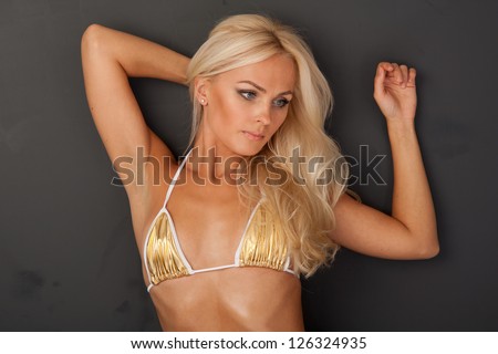 Beautiful girl in a bathing golden suit