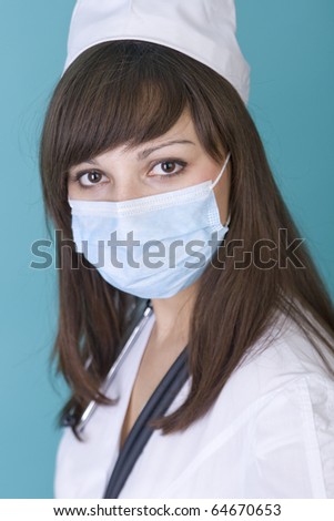 young woman doctor wearing a surgical mask on a blue background