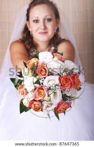 bride stretches a beautiful bouquet of orange and white roses