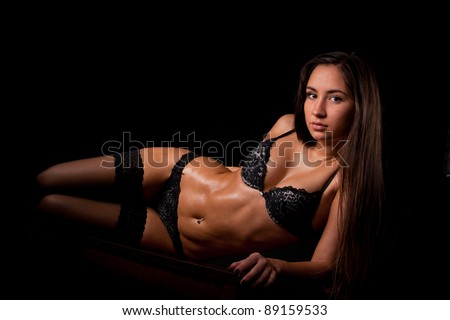 Young beautiful girl naked isolated on a black background