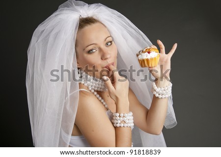 bride in veil and pearls lavish decorations eat delicious cake with jam licking fingers