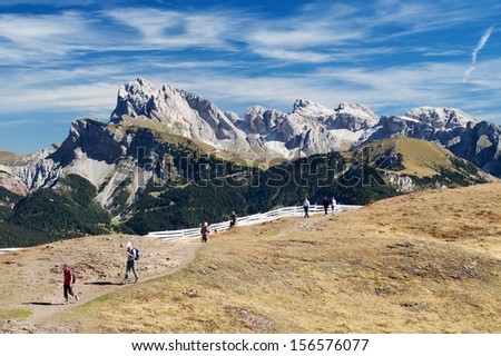 DOLOMITES, ITALY - SEP 23: Tourists on a mountain trail, September 23, 2013 in Italy. A tourist hot spot offering many seasonal activities such as skiing, mountain climbing, hiking, climbing and more.