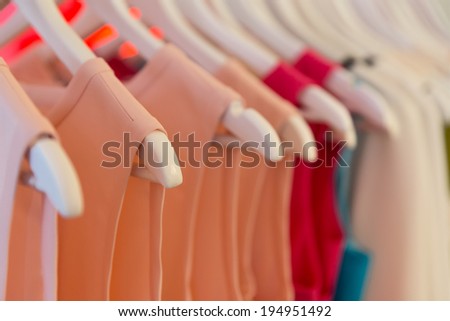 Closeup view of dresses on clothes hangers with very shallow depth of field.