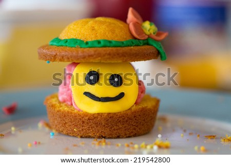 Hand made cup cake with a smiley face and crumbs