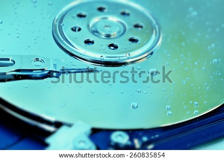 Hard drive platter covered with water drops symbolizing water damage.