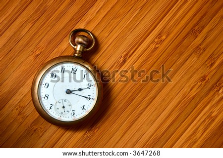 Antique pocket watch - closeup on very old pocket watch on wooden surface