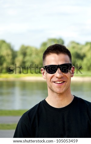 man with black glasses on green background