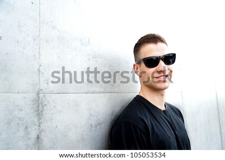 man with black glasses near the wall