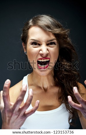 Angry woman on black background