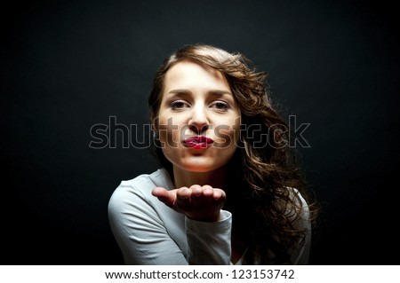 Woman with sensual kiss smile on black background