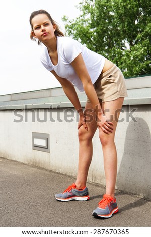 Running woman. Runner jogging in sunny bright light. Female fitness model training outside in  City with skyline.