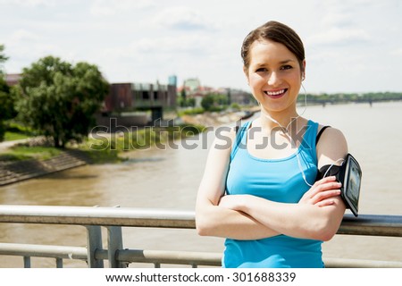 Young tired woman rest after run in the city over the bridge smiling.