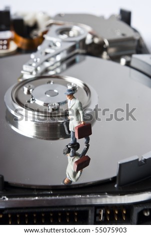 one miniature man with suitcase on hard drive