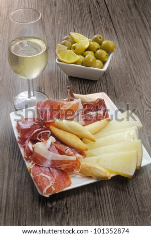 cured iberian ham and cheese tapas with sherry wine and olives