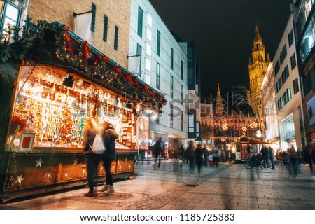 Blurred moved people and sales booth at the christmas market on Marienplatz against Town Hall Neues Rathaus in Munich, Germany