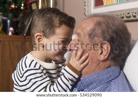 Grandfather and grandson playing and smiling at home