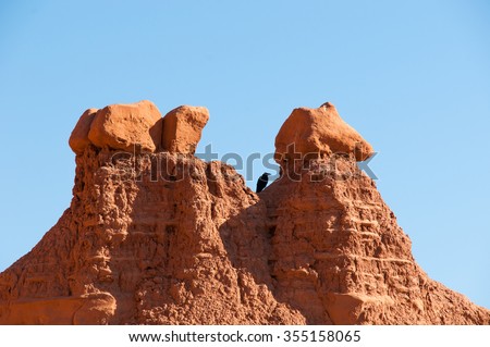 Geological formations in southern Utah with a small black bird