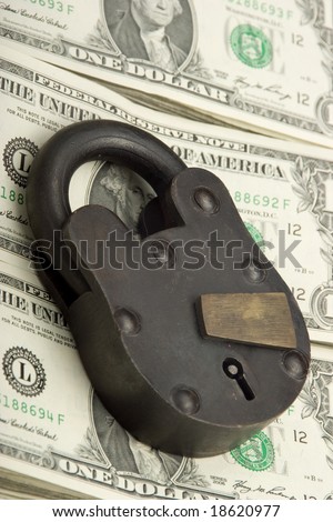 big lock on pile of cash FINANCIAL SECURITY CONCEPT
