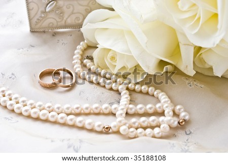 two rings and pearls and white roses
