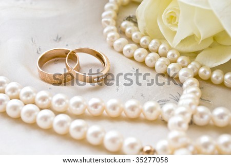 two rings and pearls and white roses