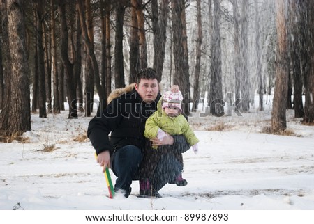 family of three throwing snow