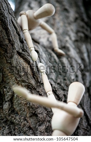 a wooden dummy wooden little man held out another helping hand to vzabratsya on a tree branch, to help overcome the obstacle