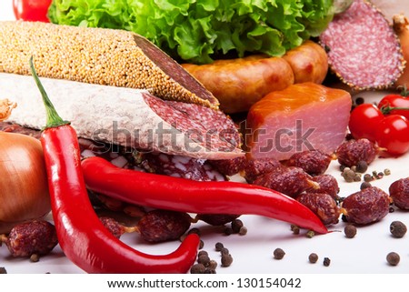 cold cuts from different kinds of meat and vegetables on a white background